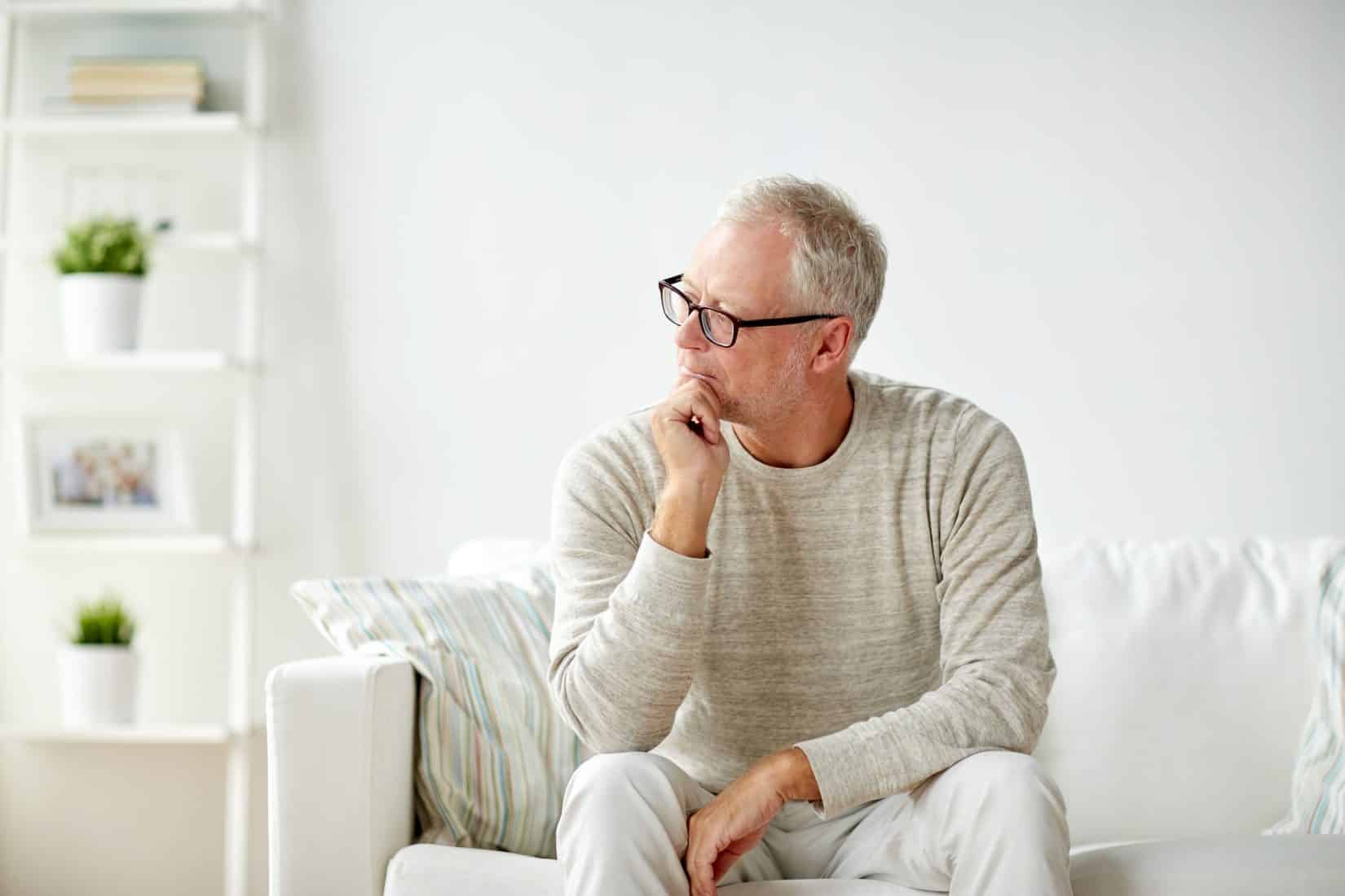 Older Man Sitting on Couch and Thinking