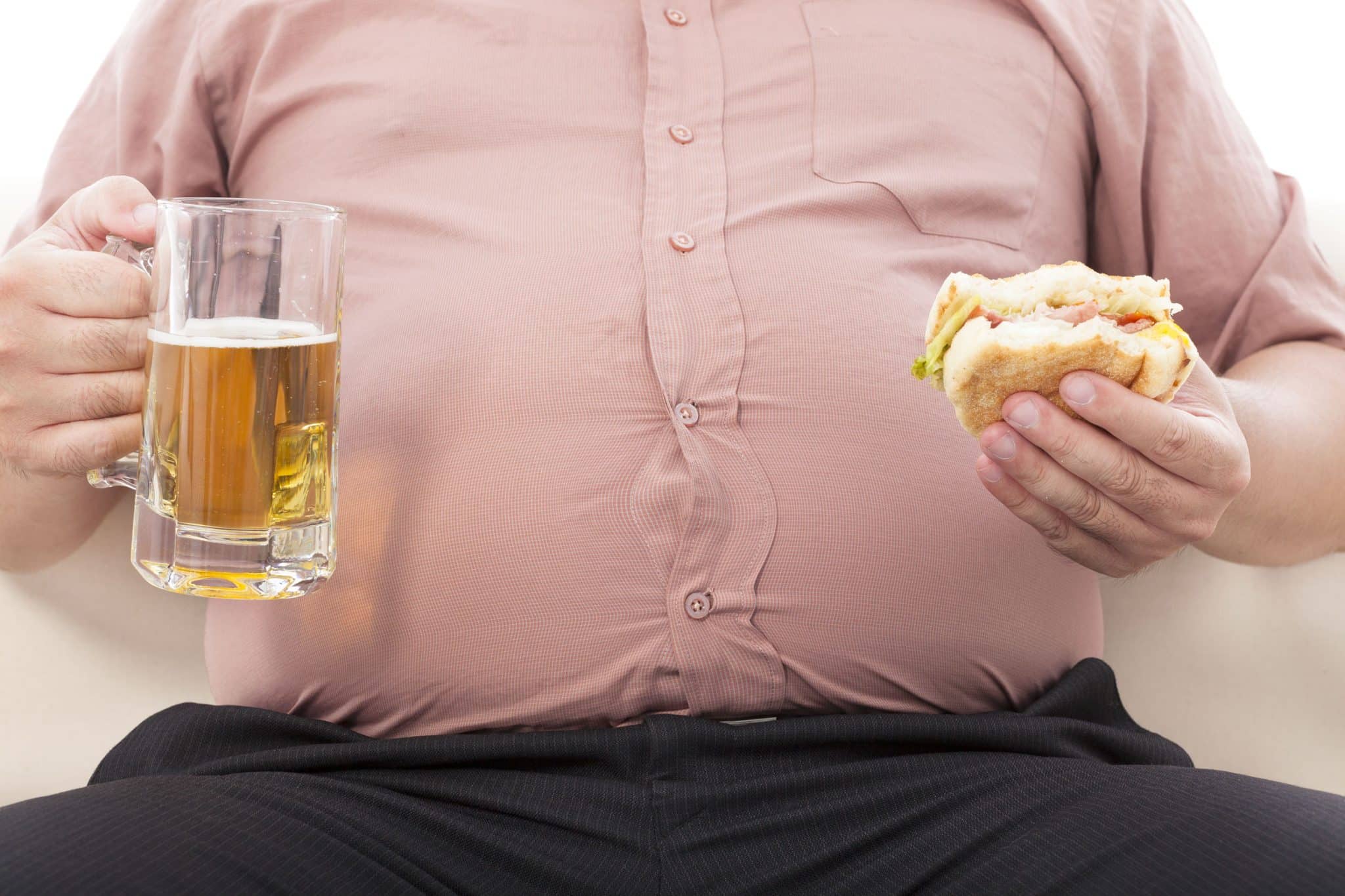 Overweight Man Drinking Beer and Eating Burger